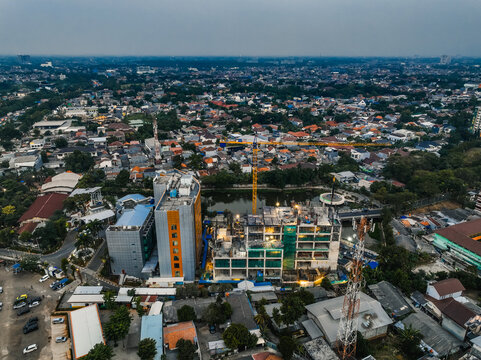 Kecamatan Cipayung, Daerah Khusus Ibukota, Indonesia - 24 July 2026: Aerial view of the Bambu Apus construction site with a tall yellow crane and dense residential housing.