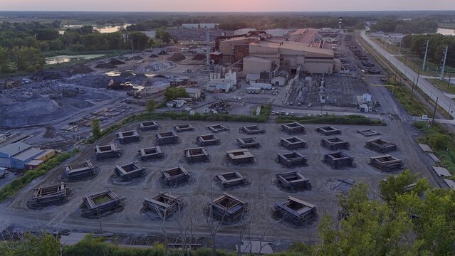 Monroe, Michigan, United States - 25 July 2026: Aerial view of the Gerdau Special Steel Monroe facility, showing industrial buildings, material stockpiles, and organized steel stacks at sunset.