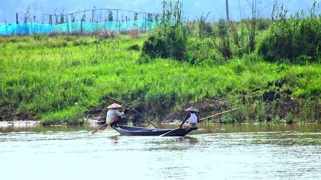 Traditional Fishermen Catching Fish from Small Wooden Boat on Calm River in Rural Landscape 4K,