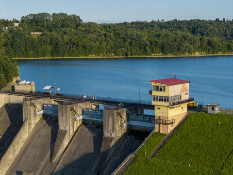 Dobczyce, Poland - 22 July 2026: Aerial view of Zapora wodna w Dobczycach, a concrete dam with a control tower, surrounded by green hills and blue reservoir waters.