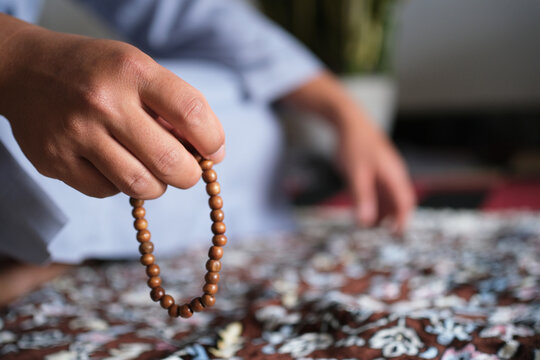 Close-up of hands reciting dhikr using prayer beads. Hands reciting dhikr. A man reciting dhikr while holding prayer beads. A Muslim's worship activity.
