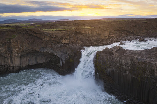 Thingeyjarsveit, Iceland - 17 June 2026: Aerial view of Aldeyjarfoss waterfall with basalt columns and turbulent water under a sunset sky.