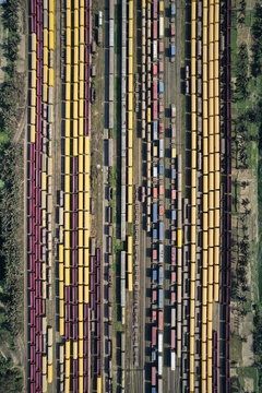 Chattogram, Bangladesh - 26 February 2025: Aerial view of the Rail Yard featuring numerous colorful freight train cars lined up on parallel tracks surrounded by lush green vegetation.