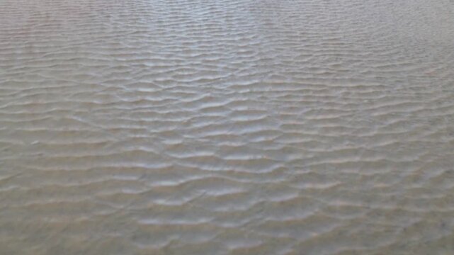 Beautiful abstract sand art peaceful background from the changing of the tide of the ocean at the beach