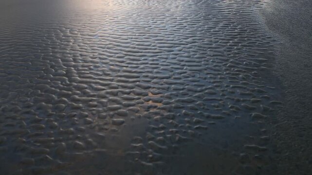 Beautiful abstract sand art peaceful background from the changing of the tide of the ocean at the beach