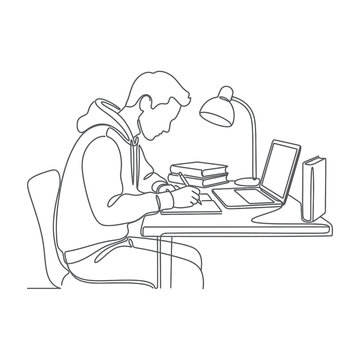 man sitting at desk working on laptop with books and lamp