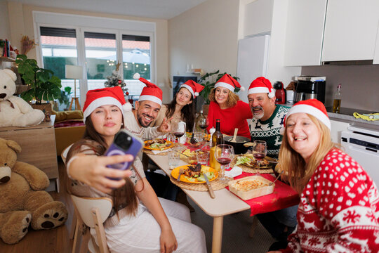 Happy family taking selfie celebrating christmas dinner together