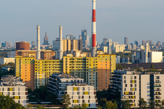 Warszawa, Poland - 14 July 2026: Aerial view of EC Zeran power station with its distinctive red and white chimney, surrounded by residential apartment blocks and the city skyline in the background.