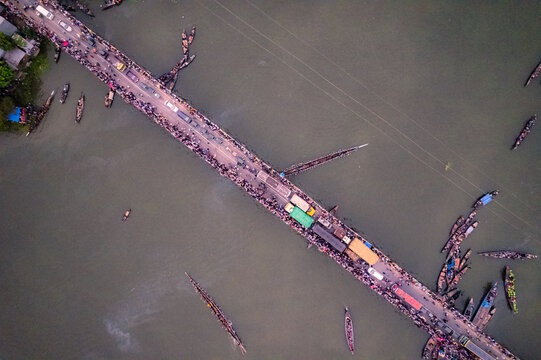 Sirajganj, Rajshahi Division, Bangladesh - 19 September 2025: Aerial view of a traditional boat race with long narrow boats on the river and spectators gathered on the bridge.