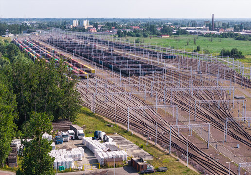 Gdansk, Poland - 17 July 2026: Aerial view of a large railway marshalling yard featuring numerous parallel tracks, freight trains, and a logistics area with trucks and white cargo bags.
