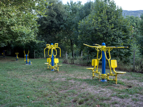 Gimnasio al aire libre en un parque entre la naturaleza donde se pueden observar las m&aacute;quinas de hacer ejercicio entre los &aacute;rboles.