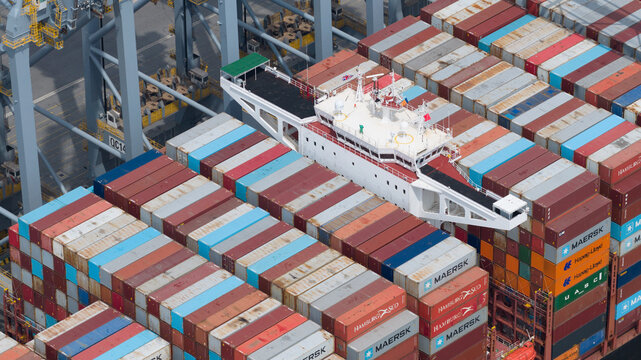 Corringham, United Kingdom - 10 July 2026: Aerial view of Solent Stevedores London Gateway container terminal with a cargo ship stacked with colorful shipping containers.