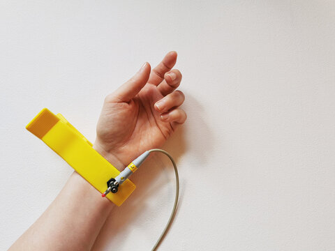 Human hand with ECG electrode on wrist, heart health check, pulse diagnostics