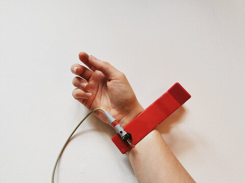 Human hand with ECG electrode on wrist, heart health check, pulse diagnostics