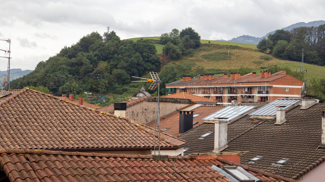 Tejado de pueblo frente a colina verde en Villabona, Guipuzcoa, Espa&ntilde;a