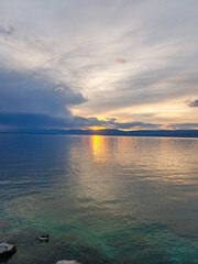 Obraz premium Golden sunset reflection on Lac Leman with duck swimming near shore, thonons les bains