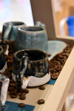 handmade blue ceramic coffee cups on wooden table close up, pair of artisanal glazed pottery mugs, rustic pottery coffee set craft display with copy space