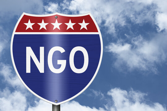 NGO text on an American interstate road sign with sky for non-government organization