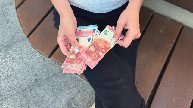 Woman counting euro banknotes indoors, personal budgeting, financial planning, cash savings, European currency.