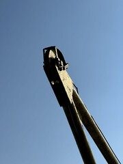 Old crane boom pulley wheel mechanism against clear blue sky © Mateusz