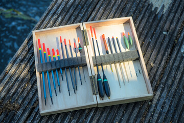 Fishing Floats Organised in Wooden Case on Jetty by River © Jon