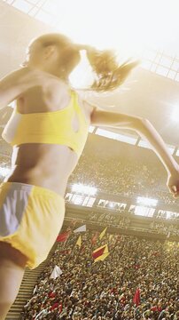 Female sprinter running at full speed under bright daytime stadium sky