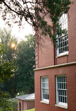 Brick building and sun peeking through trees