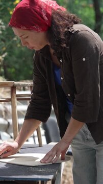 Female craftsperson cleaning and sanding an old chair during a DIY furniture restoration project