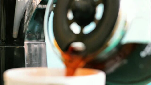 Hand grips glass coffee pot handle filled with dark rich brew, clear marked glass reflects soft warm indoor light
