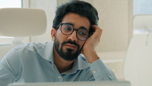 Sleepy tired Arabian Indian male business man exhausted working boring online job in office burnout muslim businessman manager employee depression apathy overworked worker stress work mental health
