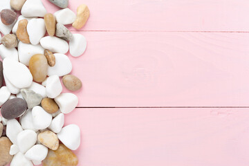 White pebble stones on wooden background, top view © Liami
