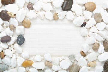 White pebble stones on wooden background, top view © Liami