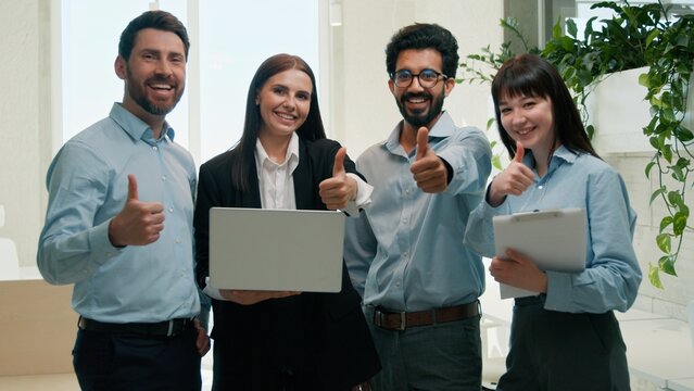 Diverse business team discussing project CEO in office thumbs up approval men woman using laptop teamwork corporate staff multiracial employees good decision leadership meeting collaboration success