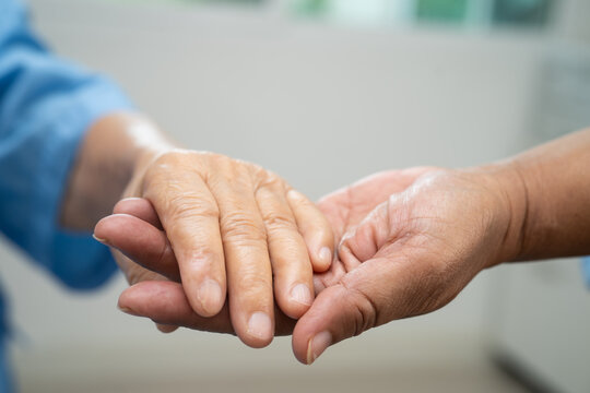 Caregiver holding hands Asian elderly woman patient, help and care in hospital.