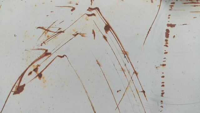 Distressed Steel Surface Light grey painted metal with brown oxidizing scratches forming angular shapes for industrial aesthetic designs construction backdrops and vintage themes