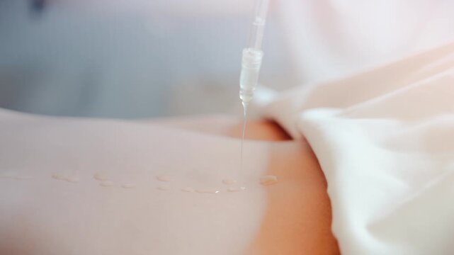 View of a professional skincare treatment with serum being applied from a dropper onto a person's back in Samana, Samana Province, Dominican Republic.