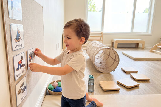 Toddler Using Wall Mounted Visual Routine Cards at Home