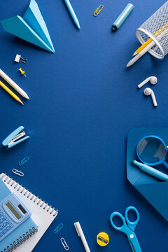 Back to school vertical flat lay with blue stationery and study supplies on dark blue background
