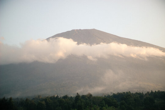 Large majestic mountain peak partially covered by thick white clouds in the morning