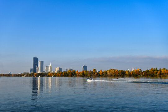 Waterskiing on Danube River with Speedboat and Vienna Donau City Skyline in Autumn Austria