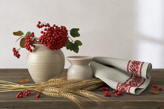 Traditional pokrov day still life with red rowan berries, wheat, ceramic pottery and embroidered cloth on rustic wooden table