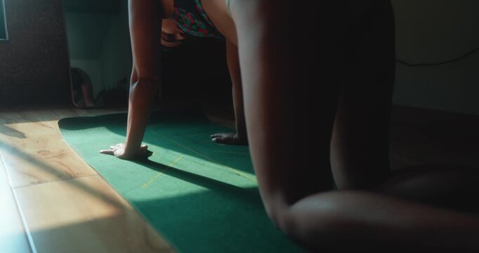 Woman performing alternating knee lift movements on a yoga mat, focusing on core stability, balance, mobility, and controlled fitness training indoors.