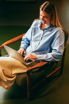 Professional woman using laptop in chair film photo