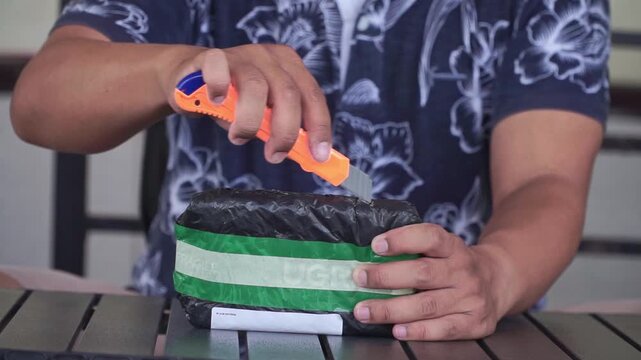 package unboxing with cutter knife, showcasing online shopping delivery, parcel opening, courier service, and consumer experience concept.