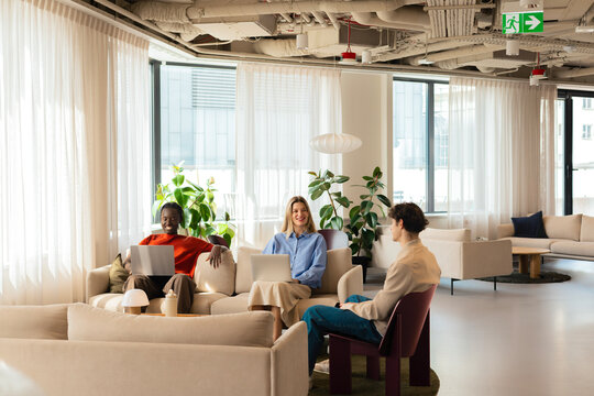 Woman and man with laptops in business office lounge
