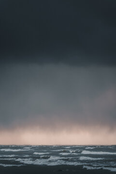 View of the stormy sea at Vormsi with dark clouds and waves crashing under a dramatic sky in Laane County, Estonia.