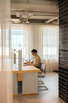 Man working on laptop in modern coworking office