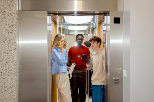 Business lifestyle group in office elevator lobby with smartphone