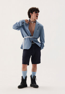 A young boy in a blue jacket on a white studio background.