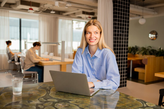 Professional business woman working on laptop in coworking space